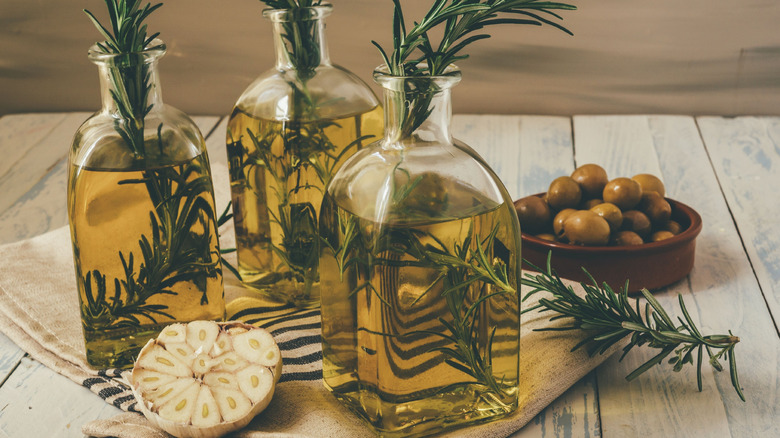 Glass bottles of olive oil have been infused with herbs.