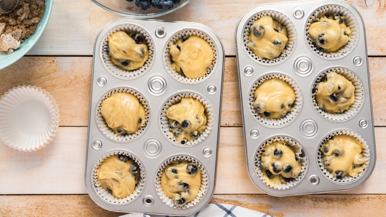 Blueberry muffin batter in tins ready to bake