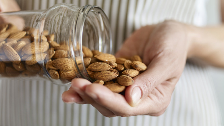 woman pouring nuts from jar