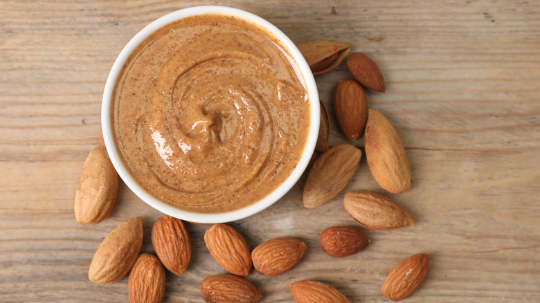 Almond butter in a bowl with almonds on the side