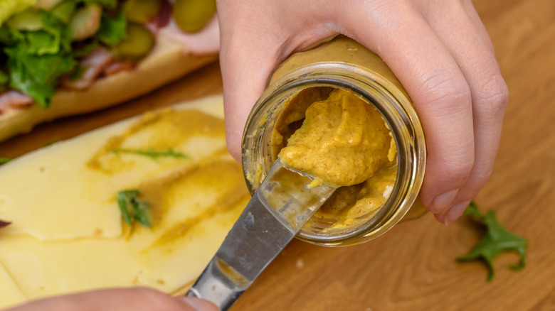 A knife in a jar of mustard