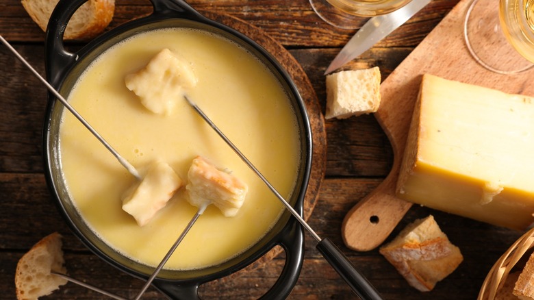 Bread-topped skewers in cheese fondue pot