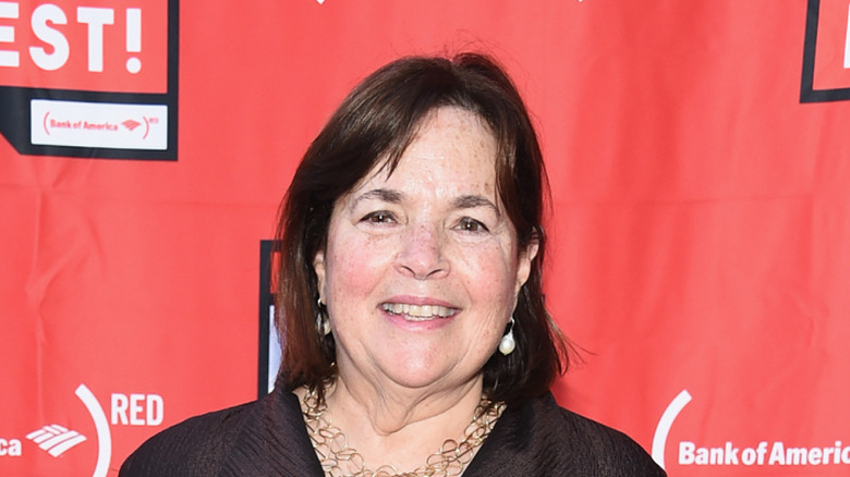 Ina Garten smiling against red backdrop