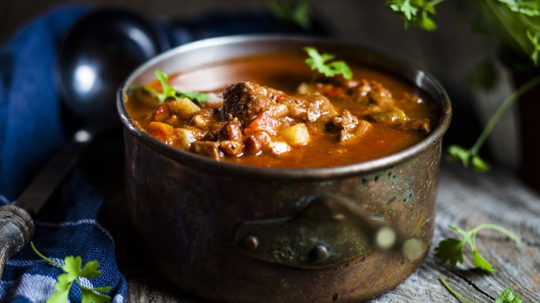 Pot of beef stew with fresh herbs