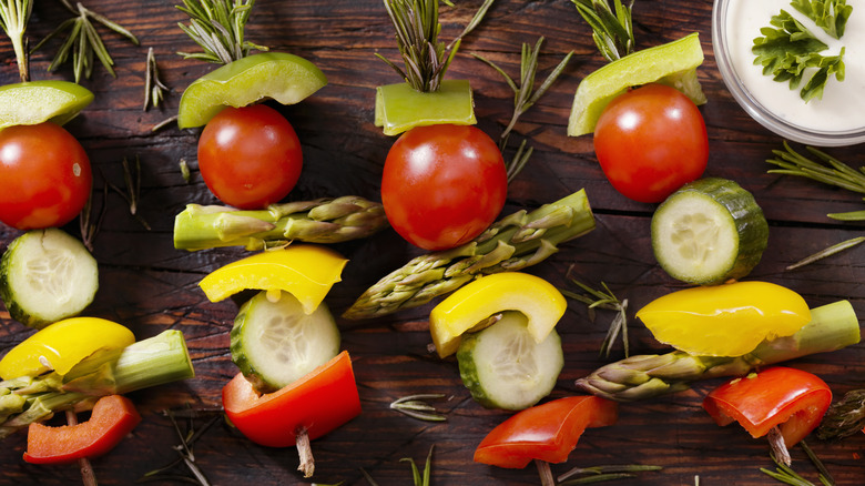 Vegetable skewers with raw asparagus, tomatoes, and peppers