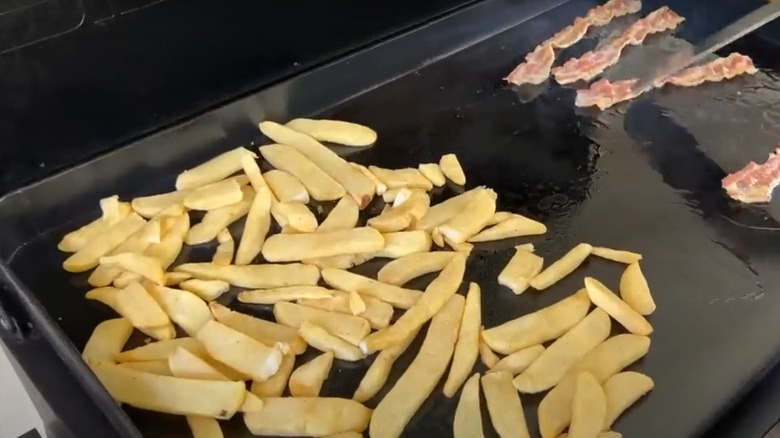 Steak fries and bacon on the grill