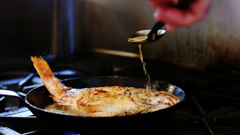 fish cooking in pan