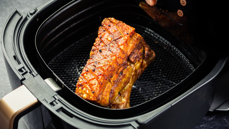 crispy pork belly inside an air fryer basket