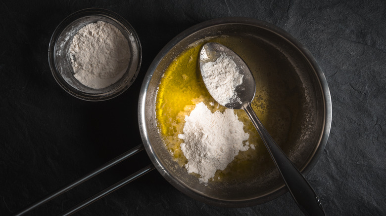 Flour in a pot with melted butter and a spoon