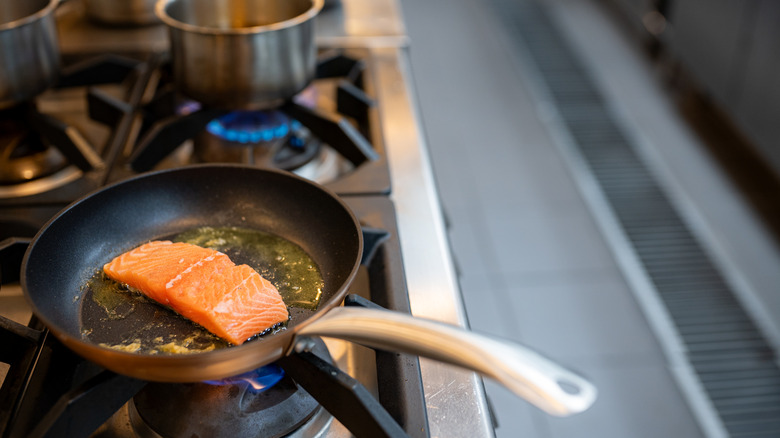 Salmon cooking in pan