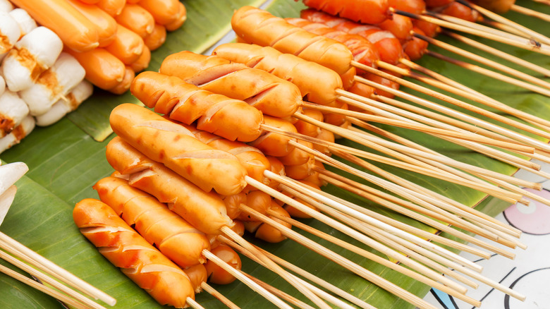 Spiral-cut hot dogs on sticks in a pile