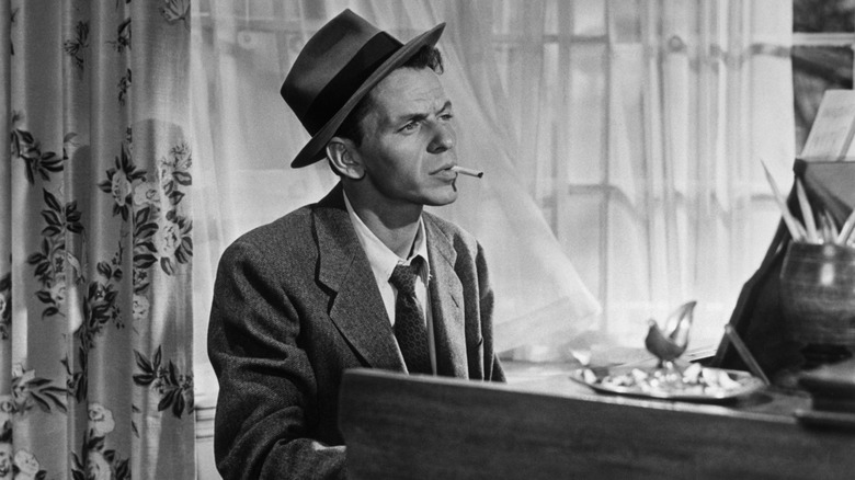 Frank Sinatra sitting at the piano with a cigarette in his mouth