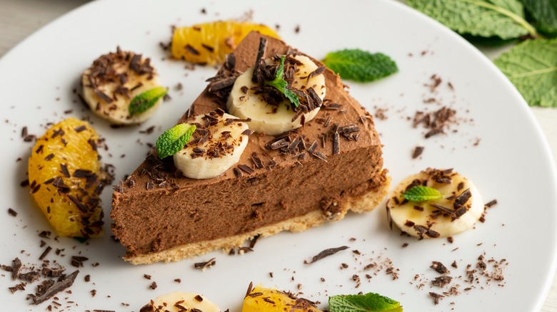 Slice of chocolate pie with fresh fruit and garnishes