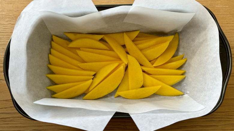 sliced mango in paper-lined pan