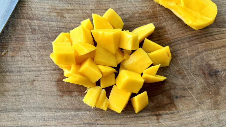 chopped mango on a wooden board