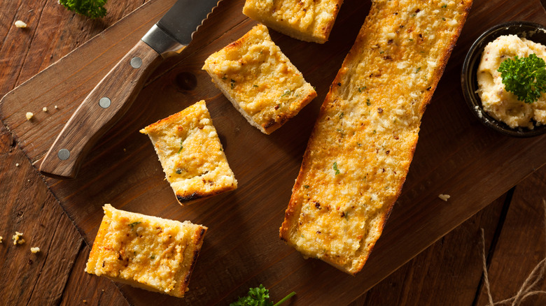 Sliced garlic bread on board