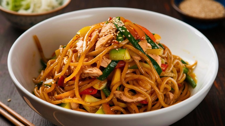 A bowl of lo mein with vegetables and chicken