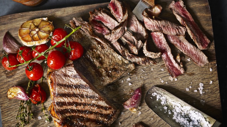 Sliced steak on cutting board with ingredients