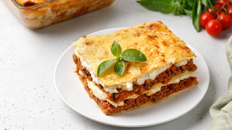 A square of freshly-baked lasagna on a plate.