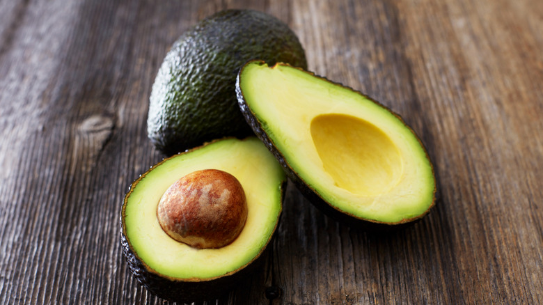 Halved avocado on a wooden background