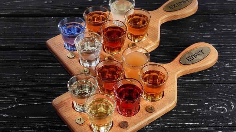 Two flights of liqueurs and liquors on wooden trays