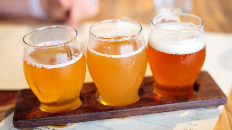 Three sampler glasses of brightly colored beer