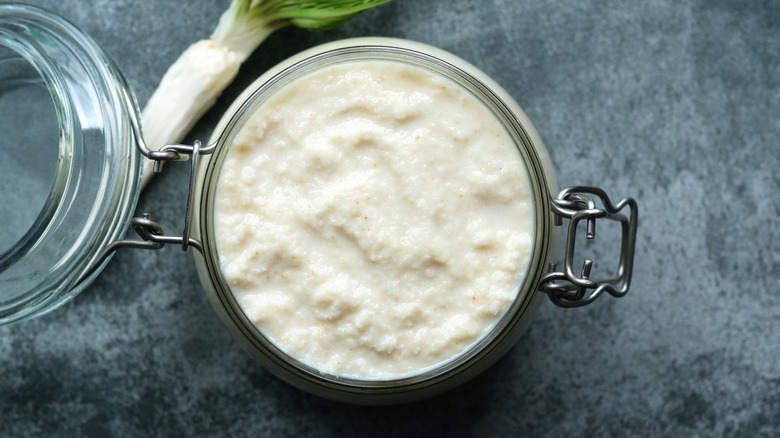 Creamy horseradish sauce in a glass canning jar with fresh horseradish