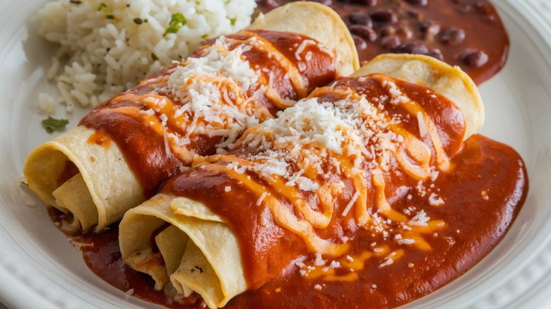 burritos on a plate covered in cheese and salsa