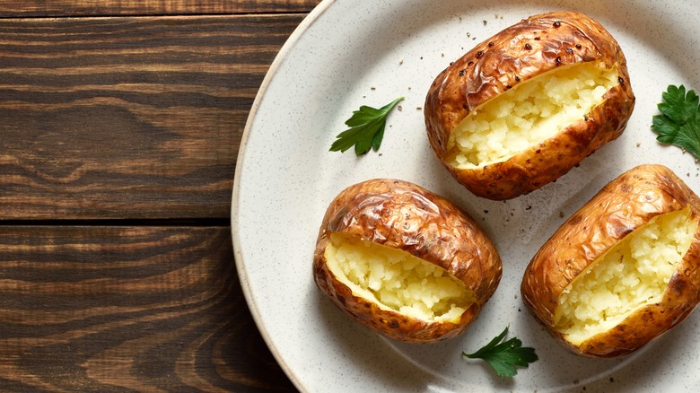 Plate of three baked potatoes