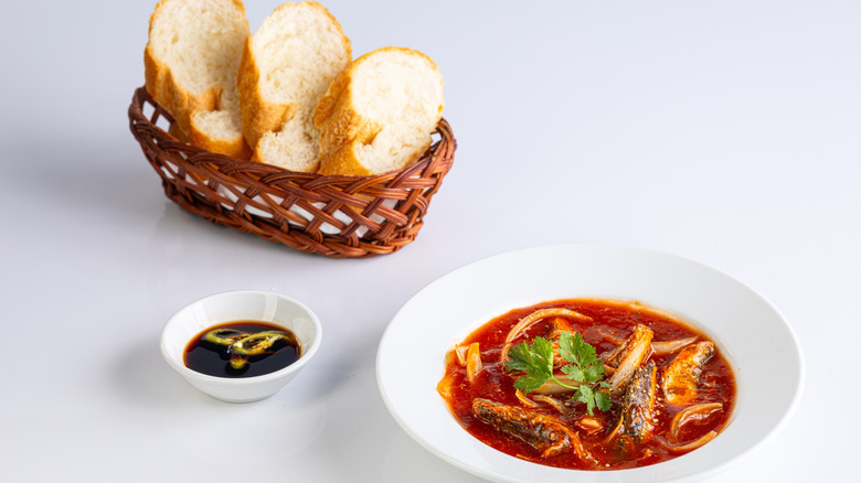 banh mi sliced alongside fish in sauce and white plate