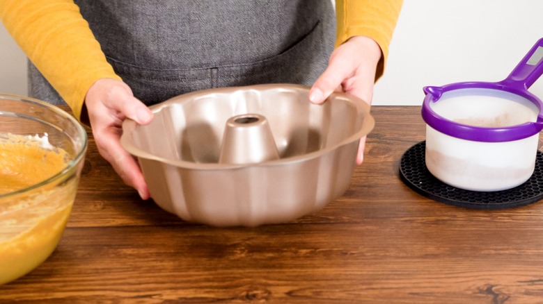 Person prepares bundt cake pan 