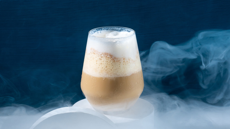 An iced coffee drink with smoke swirling around