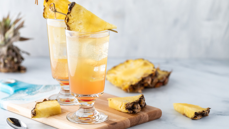 Two glasses of mimosa with pineapple pieces on top