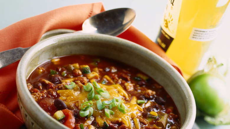 bowl of red chili garnished with cheddar cheese