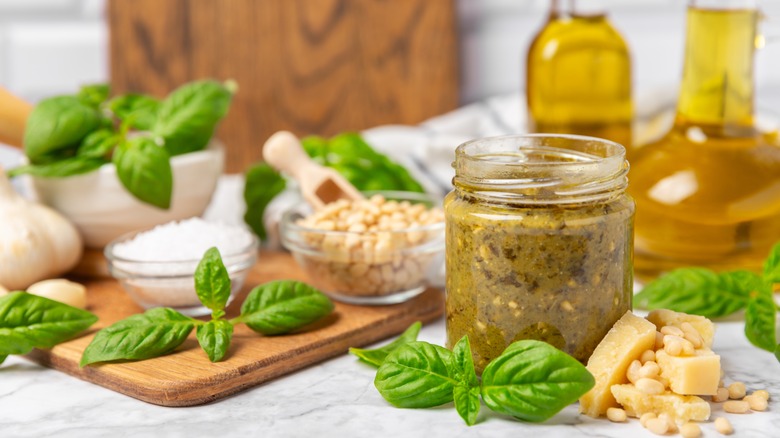 Pesto in jar surrounded by ingredients