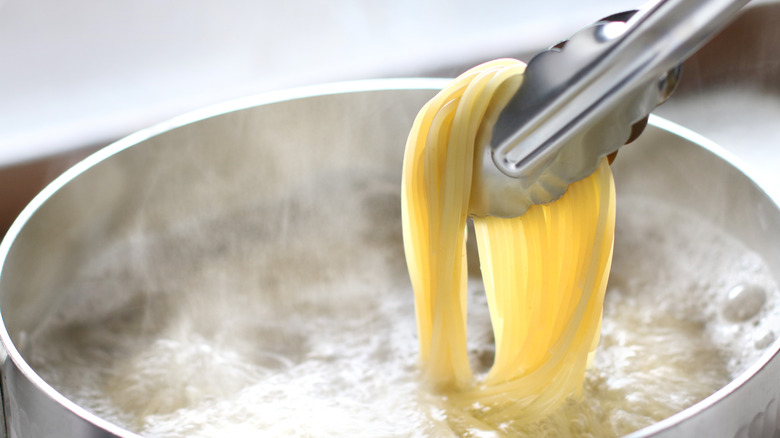 Tongs holding pasta