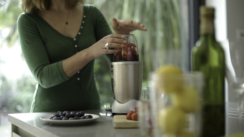 a woman using a bullet blender