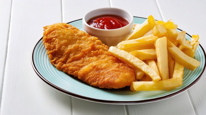 fish and chips with ketchup on a blue plate