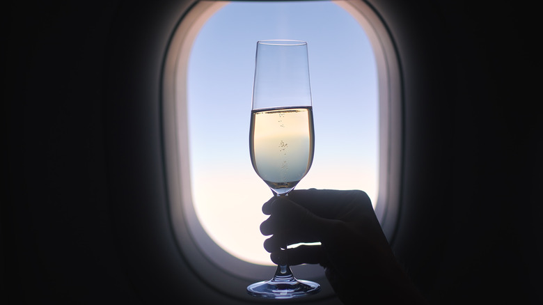 Glass of champagne in the airplane window