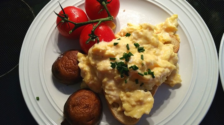 Gordon Ramsay's recipe of creamy scrambled eggs served on toast with tomatoes and mushrooms on the side