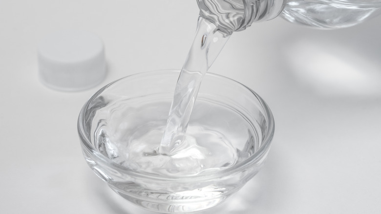 Pouring white vinegar into bowl