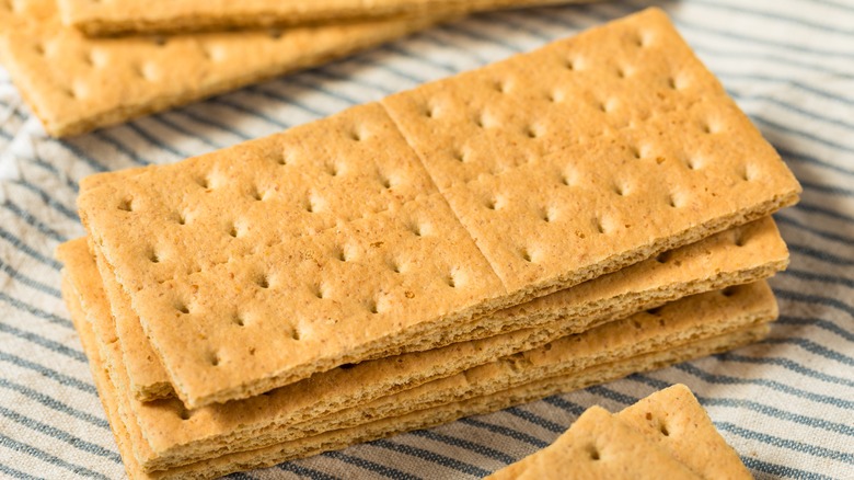 three stacks of graham crackers on a striped linen towel