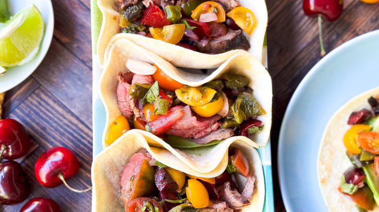 Grilled flank steak tacos with stone fruit salsa on serving platter