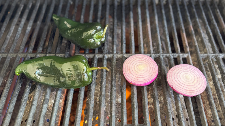 Red onion and poblano peppers on grill grates