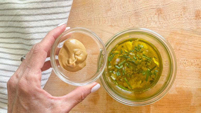 adding mustard to glass bowl