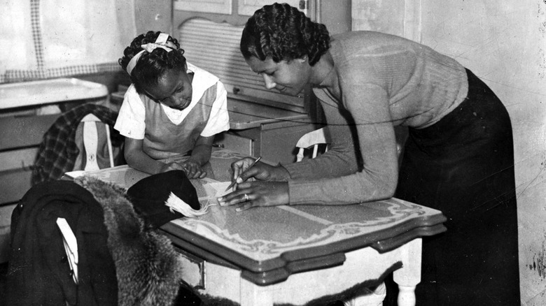 1950s woman writing a shopping list with daughter