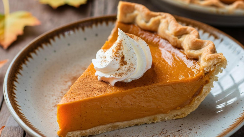 Slice of pumpkin pie with whipped cream