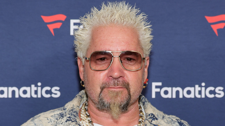 Guy Fieri against a dark blue backdrop