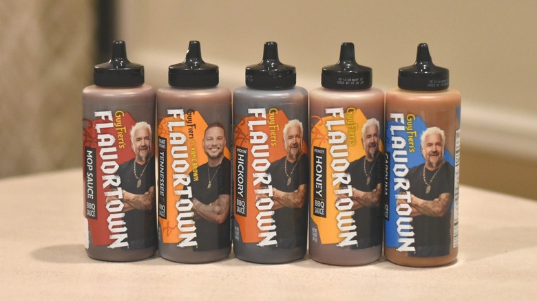 A lineup of five Flavortown barbecue sauce bottles with the labels facing forward