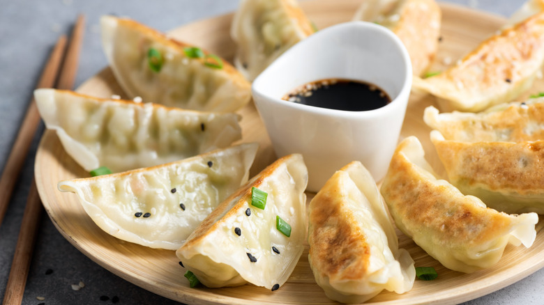 Plate of potstickers with sauce in the middle